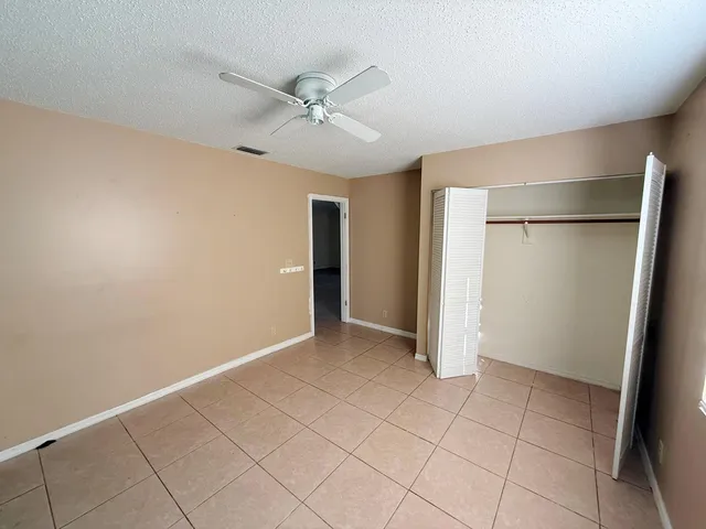 an empty room with closet and windows