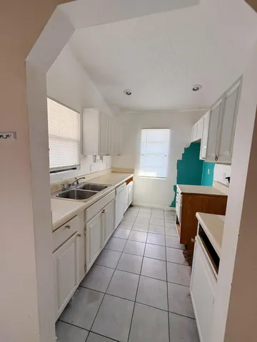 a kitchen with a sink a stove top oven and cabinets