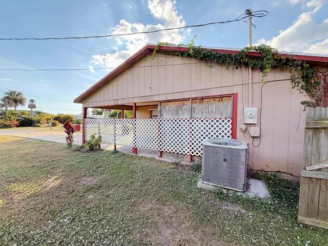 a yellow house sitting next to a yard