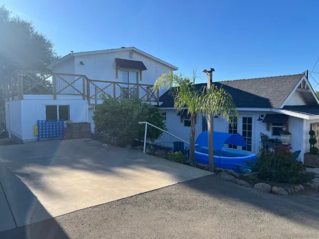 a view of a house with a yard and sitting area