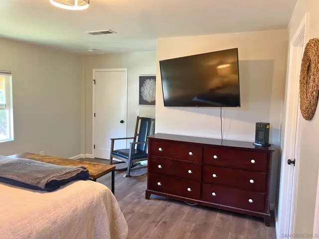 a bedroom with a bed and a flat screen tv