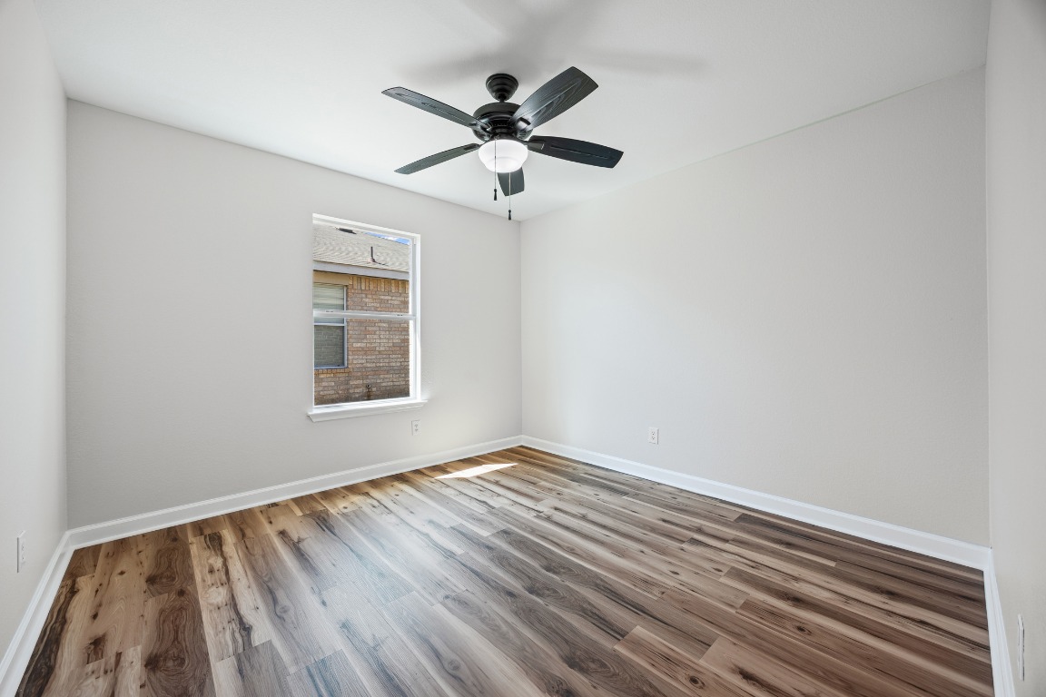 129 Lynn Crest Bend Buda, TX 78610 - Photo 13 of 16 a view of empty room with wooden floor and fan