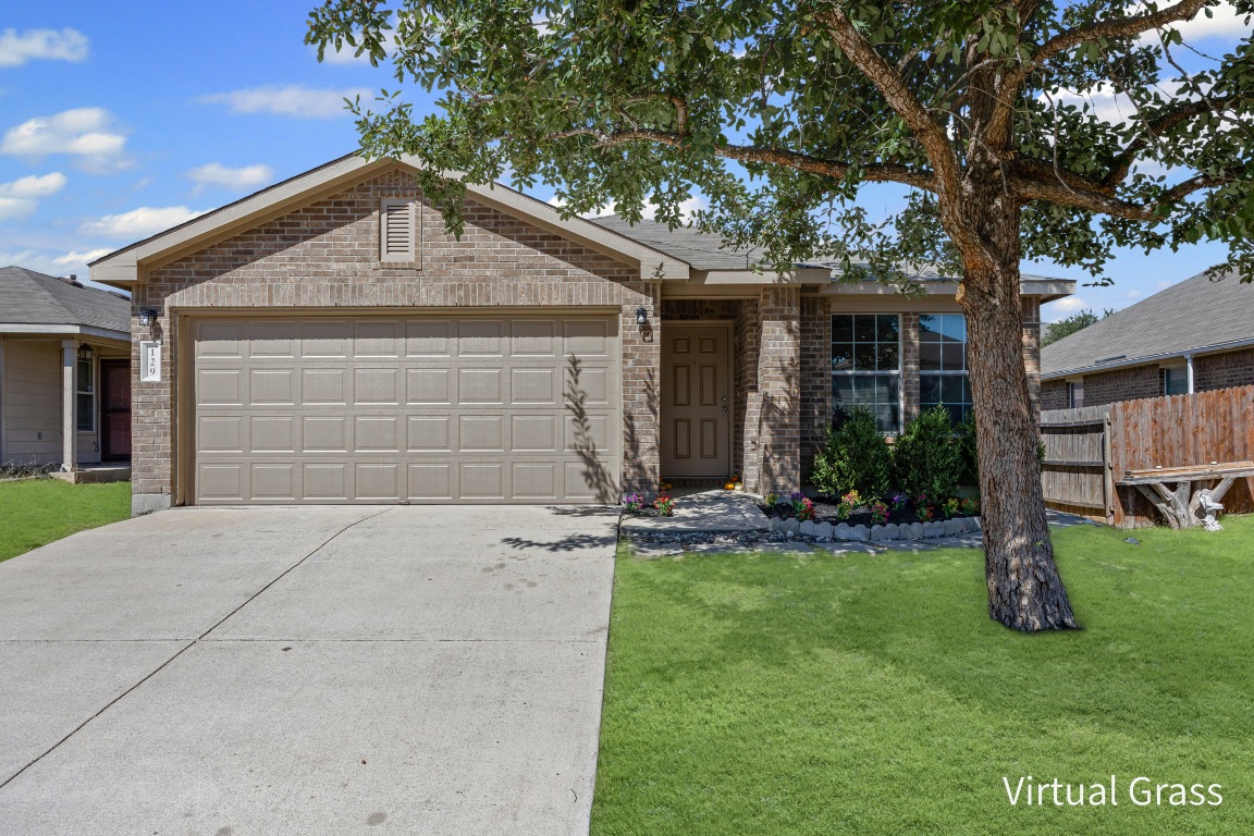 129 Lynn Crest Bend Buda, TX 78610 - Photo 2 of 16 a front view of a house with a yard and garage