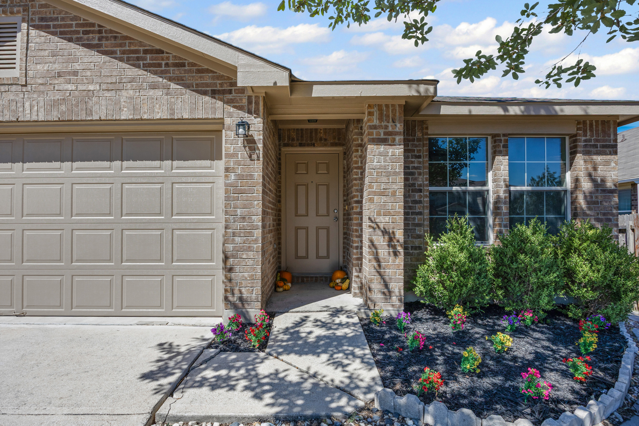 129 Lynn Crest Bend Buda, TX 78610 - Photo 2 of 14 Doorway to property featuring brick siding