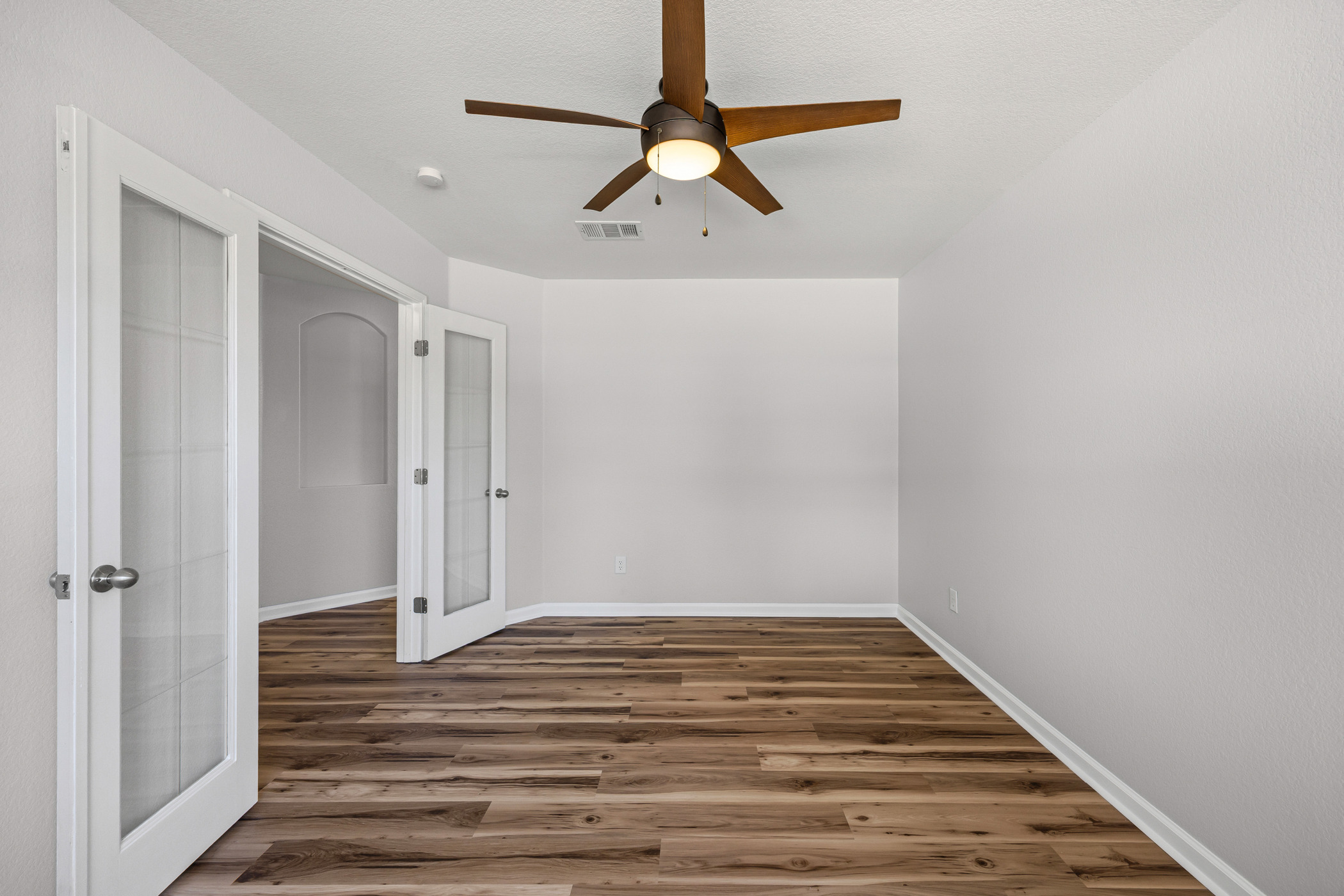 129 Lynn Crest Bend Buda, TX 78610 - Photo 4 of 14 Empty room with french doors, wood finished floors, and ceiling fan