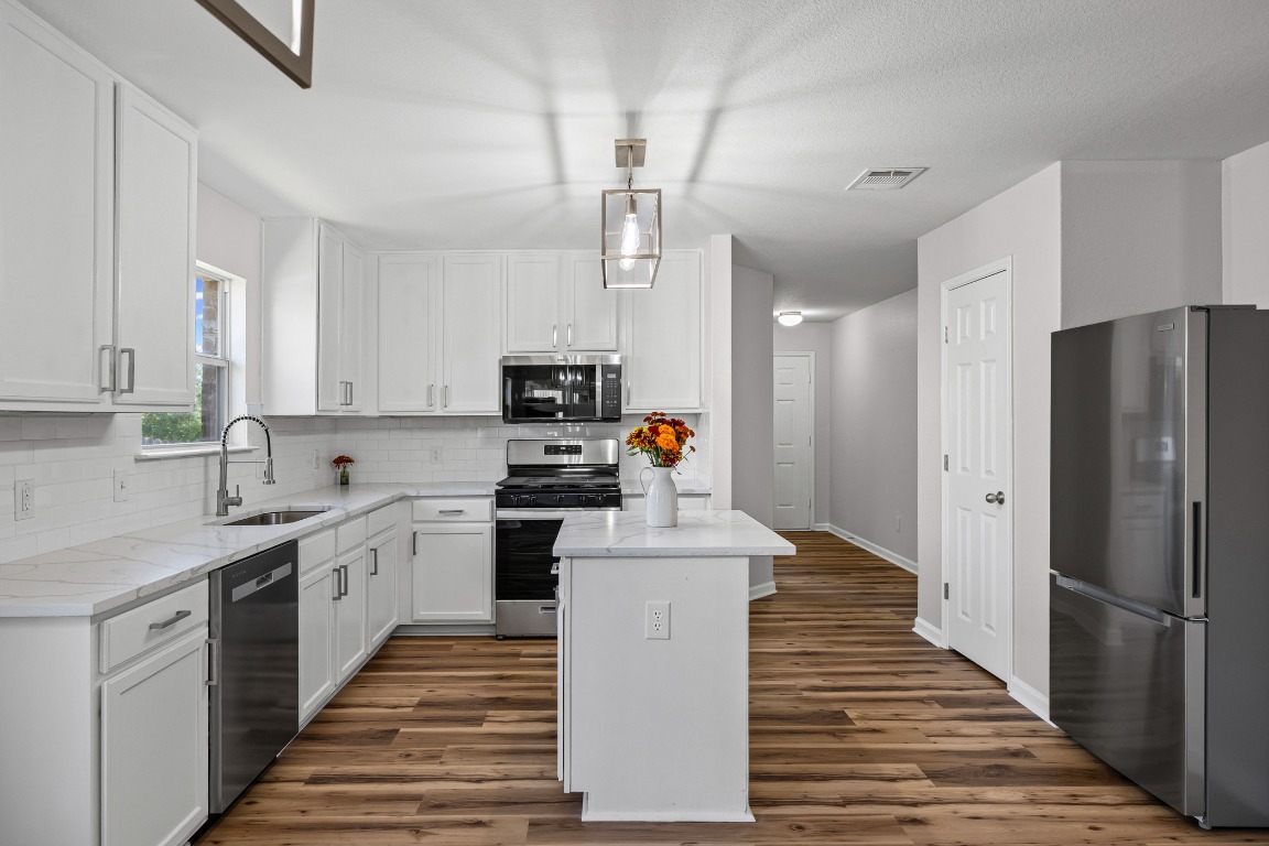 129 Lynn Crest Bend Buda, TX 78610 - Photo 5 of 16 a large kitchen with stainless steel appliances a refrigerator sink and cabinets