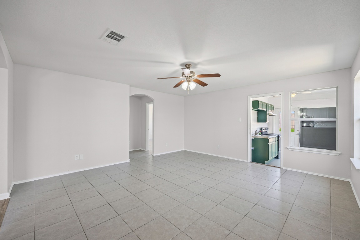 129 Lynn Crest Bend Buda, TX 78610 - Photo 6 of 16 wooden floor in an empty room with a kitchen