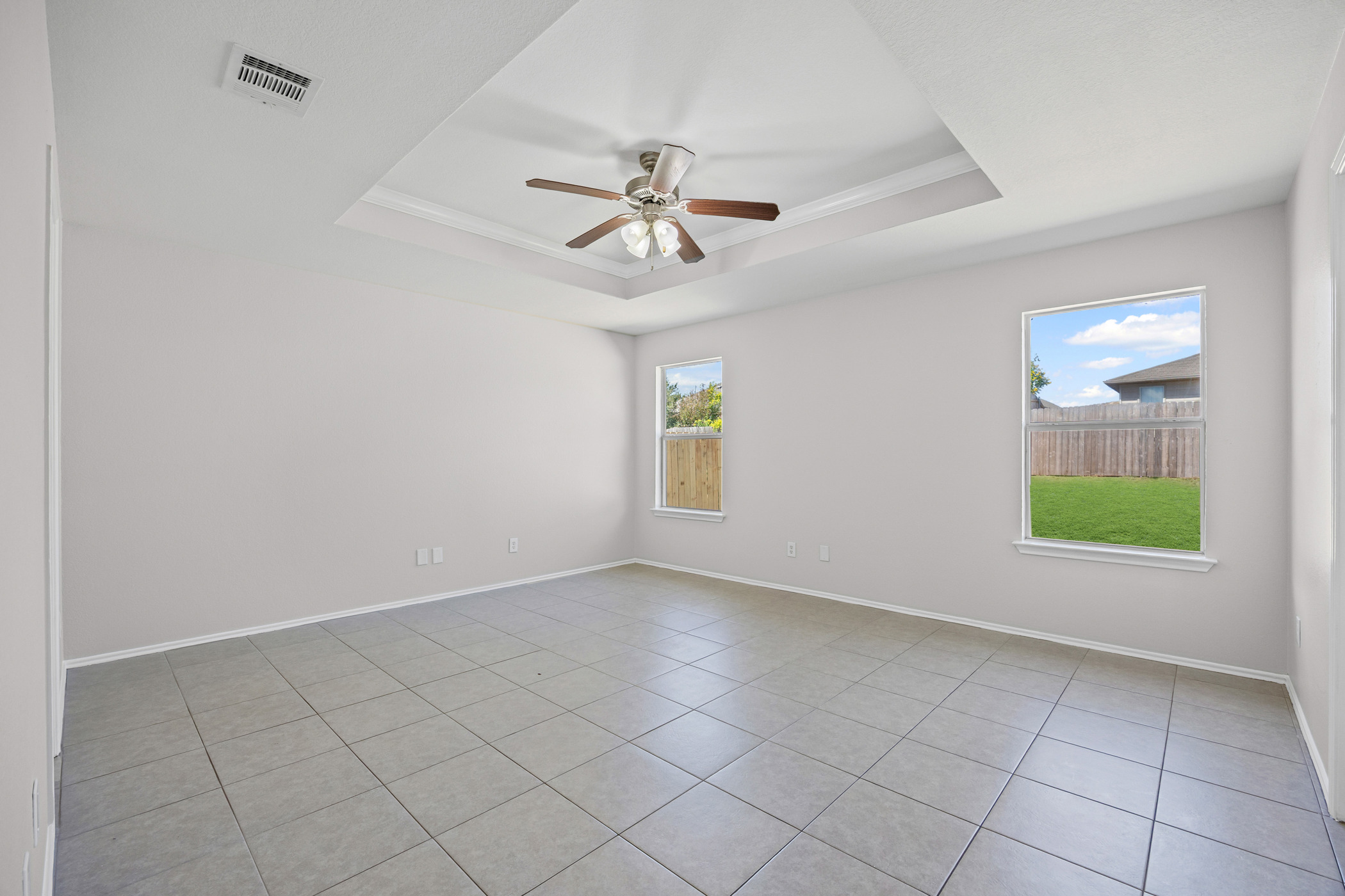 129 Lynn Crest Bend Buda, TX 78610 - Photo 6 of 14 Spare room featuring a raised ceiling, a ceiling fan, light tile patterned floors, and ornamental molding