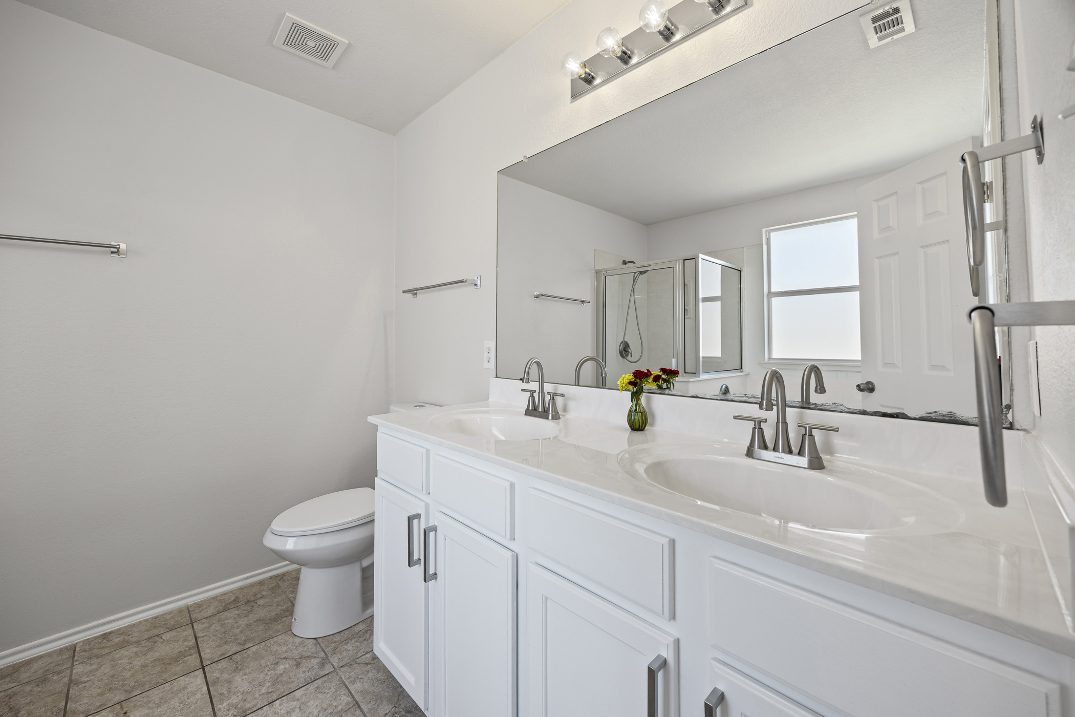 129 Lynn Crest Bend Buda, TX 78610 - Photo 7 of 14 Full bathroom featuring a shower stall, double vanity, and light tile patterned floors