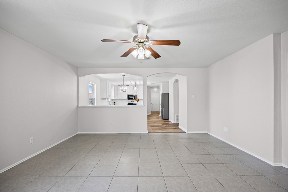 129 Lynn Crest Bend Buda, TX 78610 - Photo 7 of 16 a view of a kitchen with wooden cabinet and a ceiling fan
