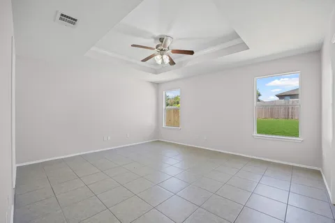 an empty room with windows and fan
