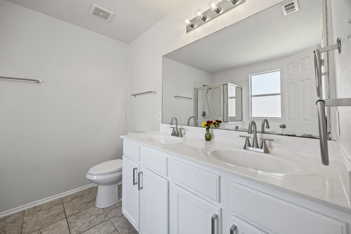 129 Lynn Crest Bend Buda, TX 78610 - Photo 9 of 16 a bathroom with a sink a toilet and mirror