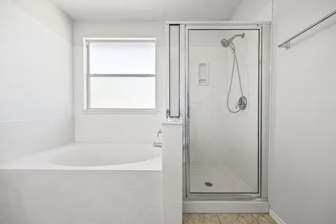 a white bath tub sitting next to a shower