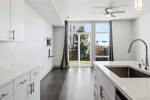 a view of a kitchen with a sink and dishwasher with white cabinets