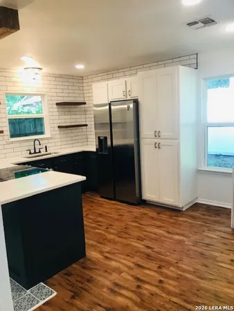 a kitchen with kitchen island a counter top space a sink and refrigerator