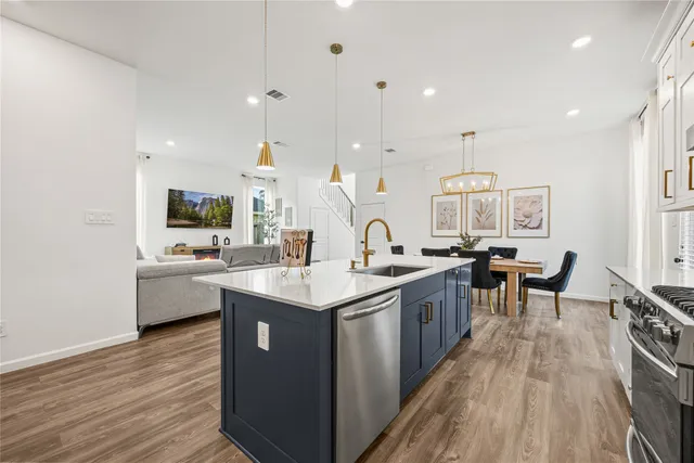a kitchen with counter top space sink stove and wooden floor