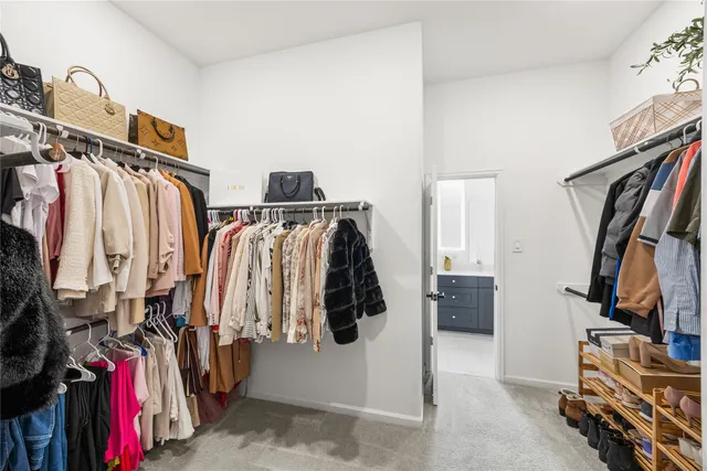 a view of walk in closet with clothes and shoes