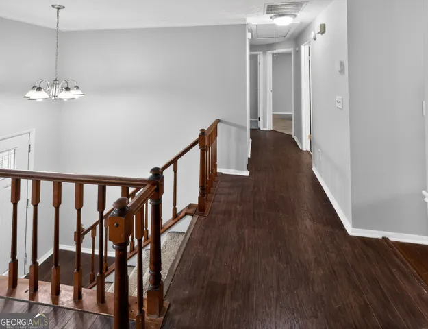 a view of a hallway with wooden floor and staircase