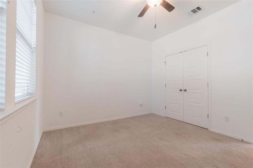 1333 Terrace View Drive Georgetown, TX 78628 - Photo 21 of 35 A well-lit bedroom features plush carpeting, a closet, and a ceiling fan for comfort.