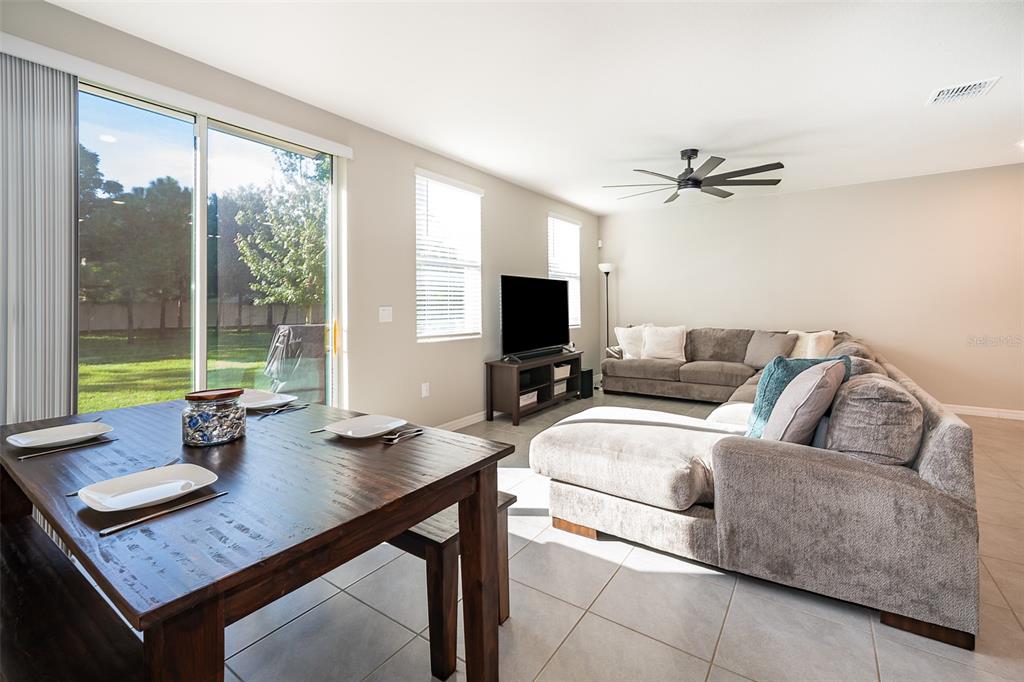 2555 Sweet Viburnum Way Ocoee, FL 34761 - Photo 12 of 26 a living room with furniture a flat screen tv and a large window