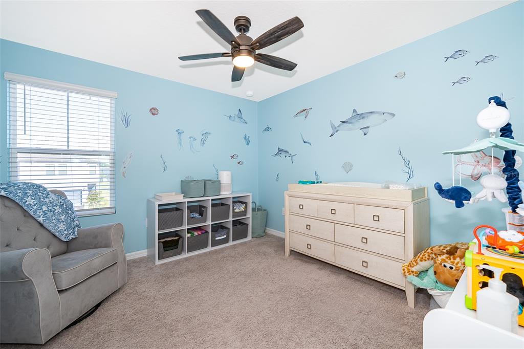 2555 Sweet Viburnum Way Ocoee, FL 34761 - Photo 18 of 26 a bedroom with a baby bed couch and a window