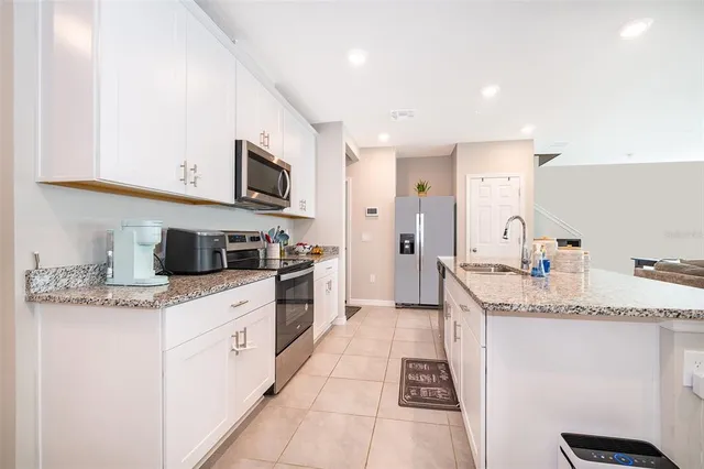 a kitchen with stainless steel appliances granite countertop a sink and dishwasher a stove top oven with wooden floor