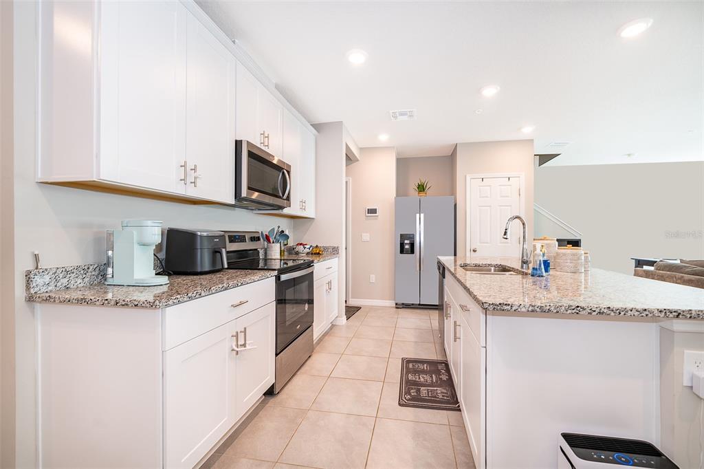 2555 Sweet Viburnum Way Ocoee, FL 34761 - Photo 7 of 26 a kitchen with stainless steel appliances granite countertop a sink and dishwasher a stove top oven with wooden floor