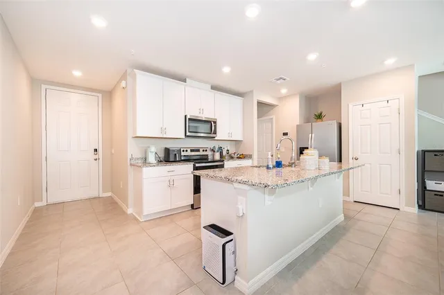a kitchen with kitchen island cabinets and refrigerator