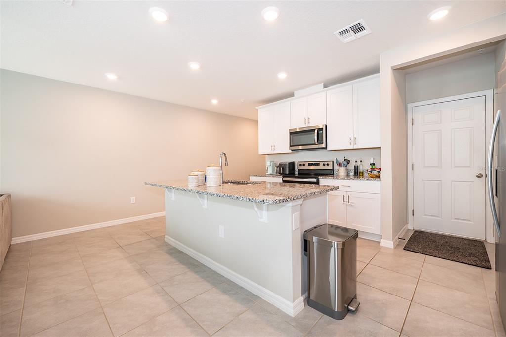 2555 Sweet Viburnum Way Ocoee, FL 34761 - Photo 9 of 26 a kitchen with granite countertop a refrigerator and a stove top oven