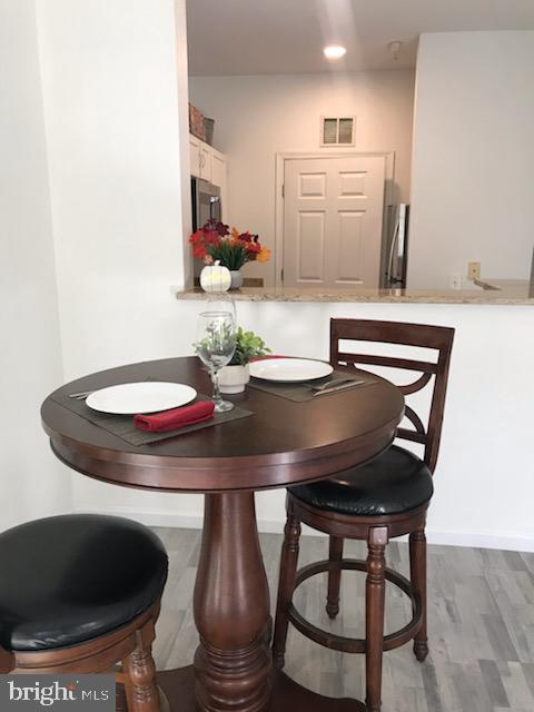 1521 Spring Gate Dr., Unit 10102 McLean, VA 22102 - Photo 15 of 46 a dining room with furniture and wooden floor