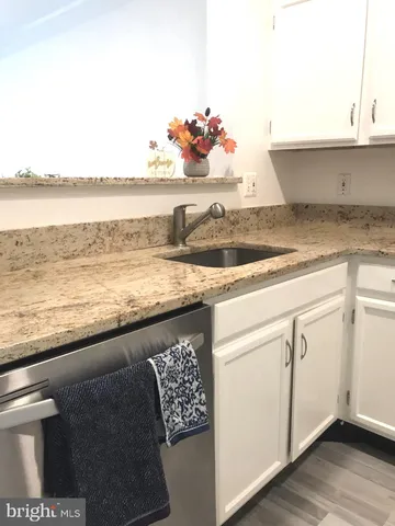 a kitchen with granite countertop lots of clutter and cabinets
