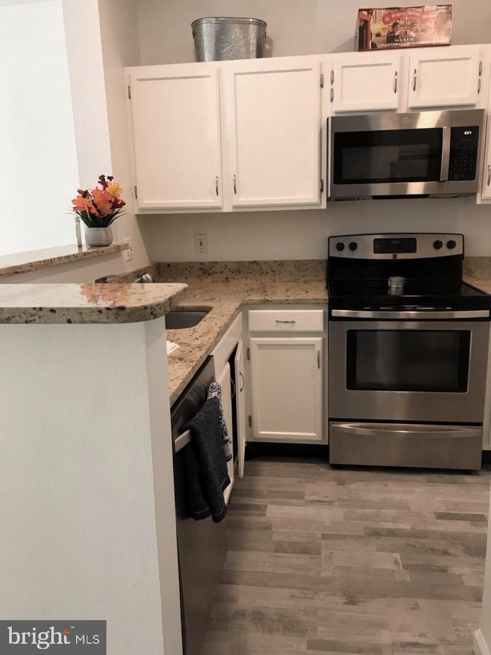 1521 Spring Gate Dr., Unit 10102 McLean, VA 22102 - Photo 9 of 46 a kitchen with stainless steel appliances a stove microwave and sink