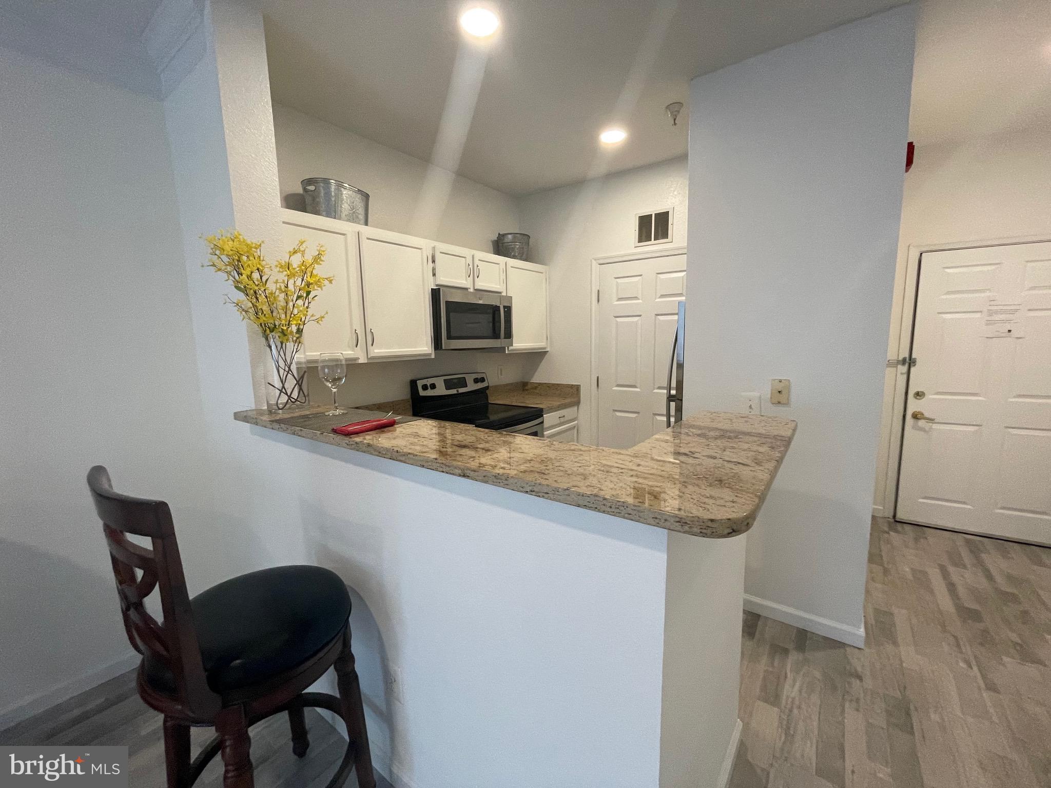 1521 Spring Gate Dr., Unit 10102 McLean, VA 22102 - Photo 10 of 46 a kitchen with kitchen island a dining table chairs stainless steel appliances and cabinets