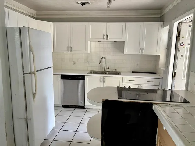 a kitchen with stainless steel appliances a refrigerator sink and cabinets