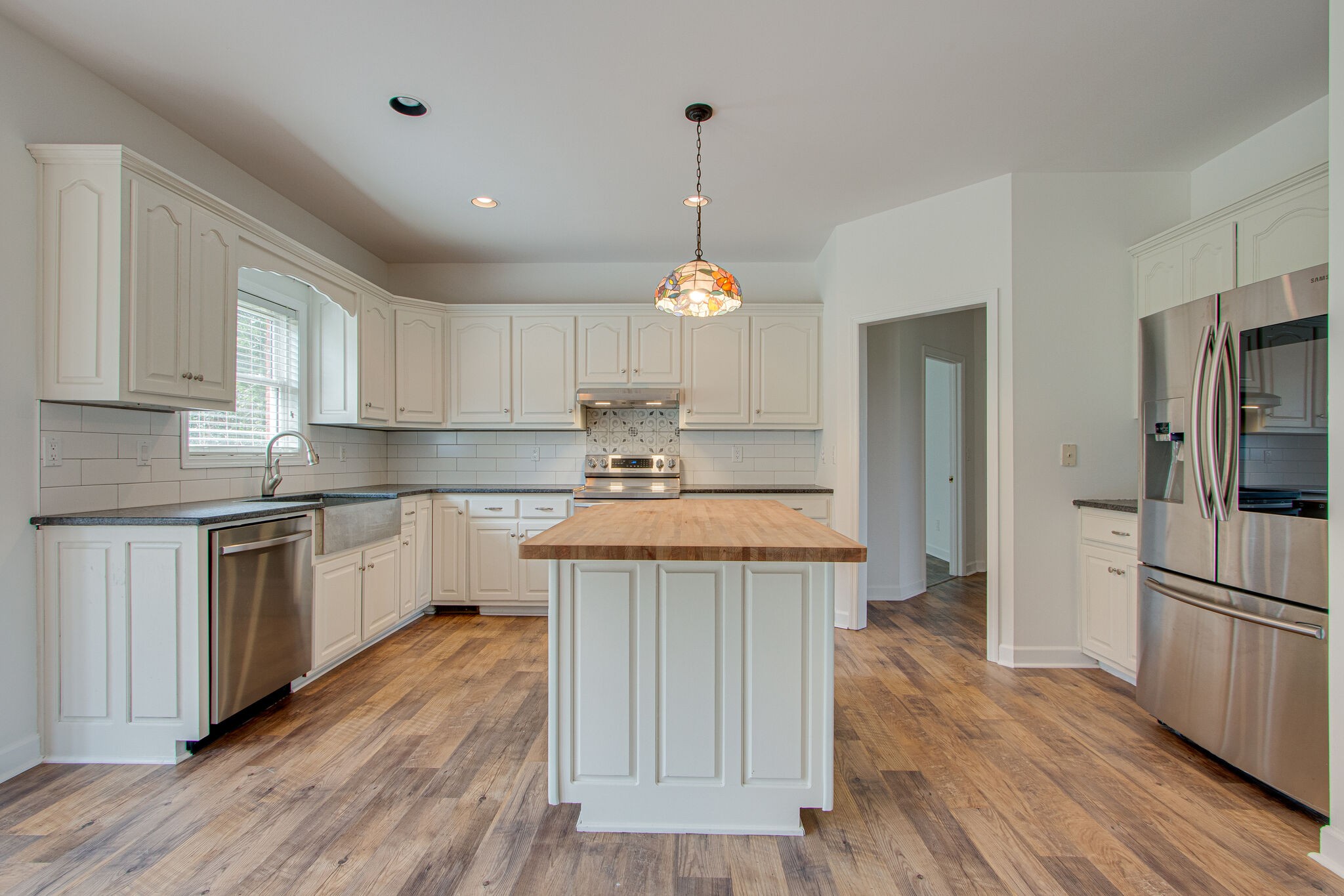 1950 Carpenter Bridge Road Columbia, TN 38401 - Photo 15 of 50 a kitchen with kitchen island granite countertop wooden floors stainless steel appliances a sink and a refrigerator