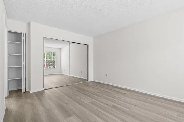 an empty room with wooden floor and windows