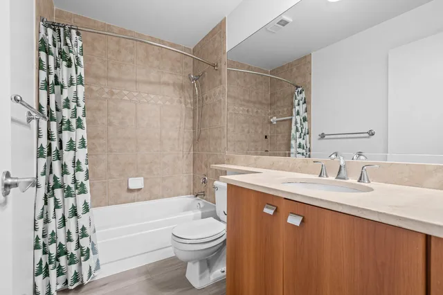 a bathroom with a granite countertop sink toilet mirror vanity and bathtub