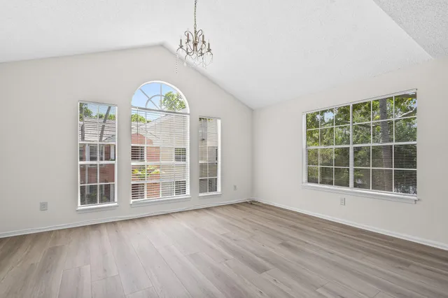 an empty room with wooden floor and a window