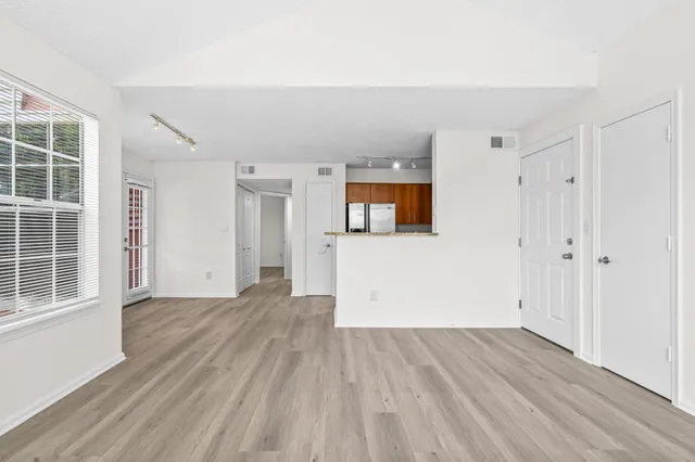 a view of empty room with wooden floor and windows