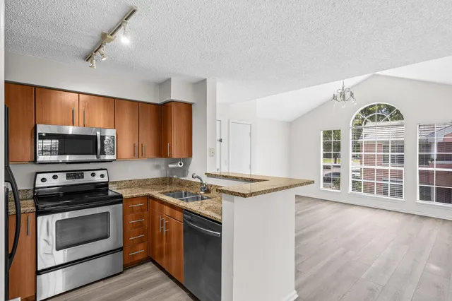 a kitchen with stainless steel appliances a stove a sink and a microwave