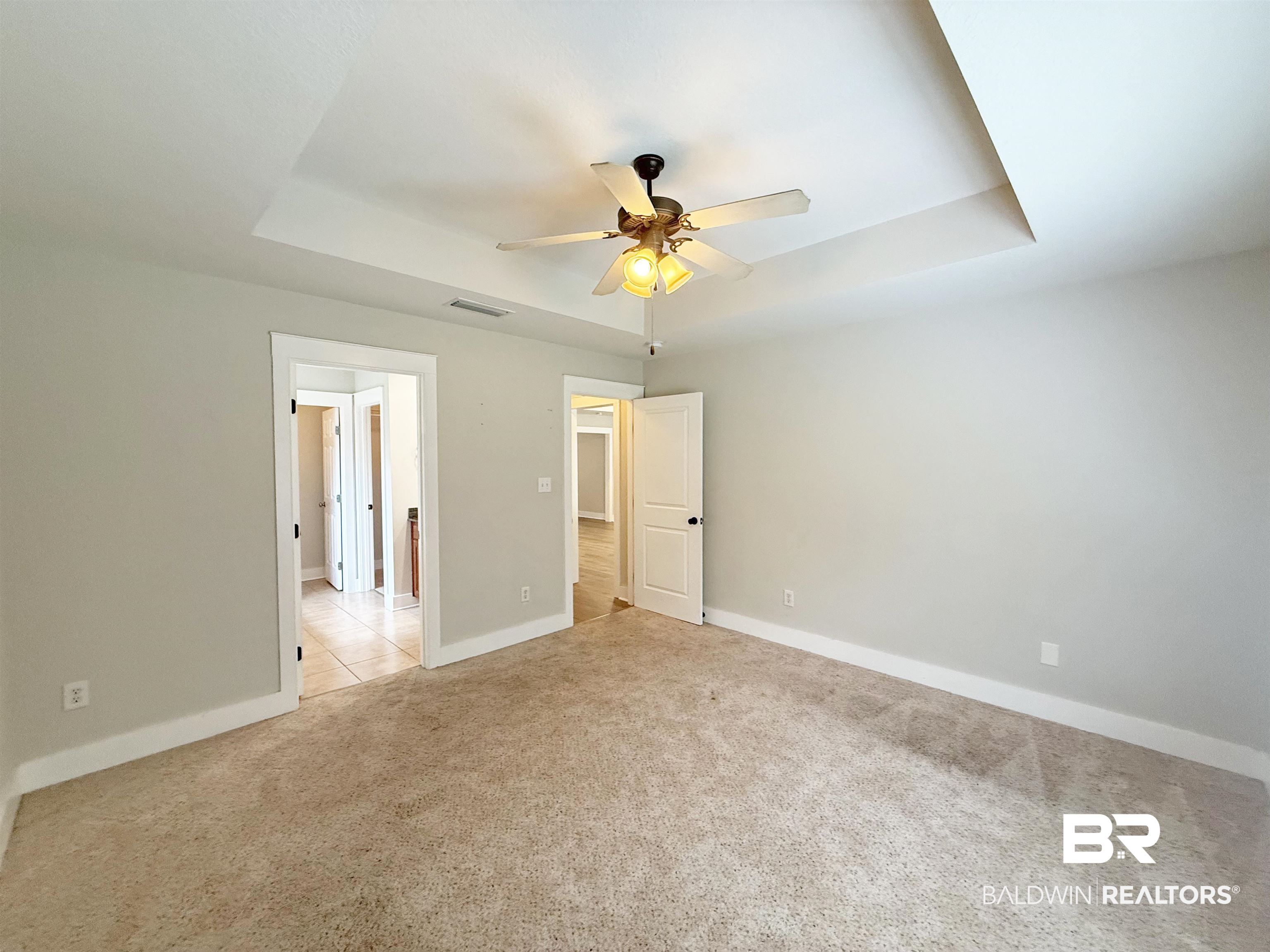 22023 Garland Loop Silverhill, AL 36576 - Photo 14 of 33 Unfurnished bedroom featuring a tray ceiling, light carpet, and ceiling fan