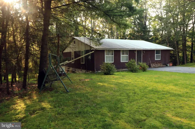 a view of swimming pool with lawn chairs and a big yard
