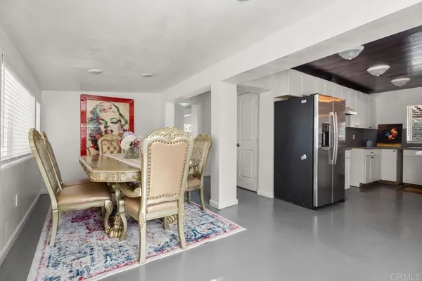 a dining room with furniture and kitchen view