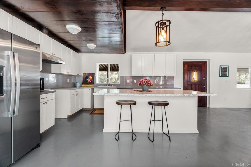 2758 Ribbonwood Road Boulevard, CA 91905 - Photo 6 of 38 a kitchen with white cabinets and stainless steel appliances