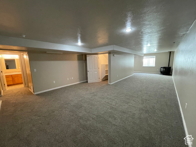 11473 South Dempsey Creek Road Lava Hot Springs, ID 83246 - Photo 25 of 47 Below grade area featuring a wood stove, carpet floors, and a textured ceiling
