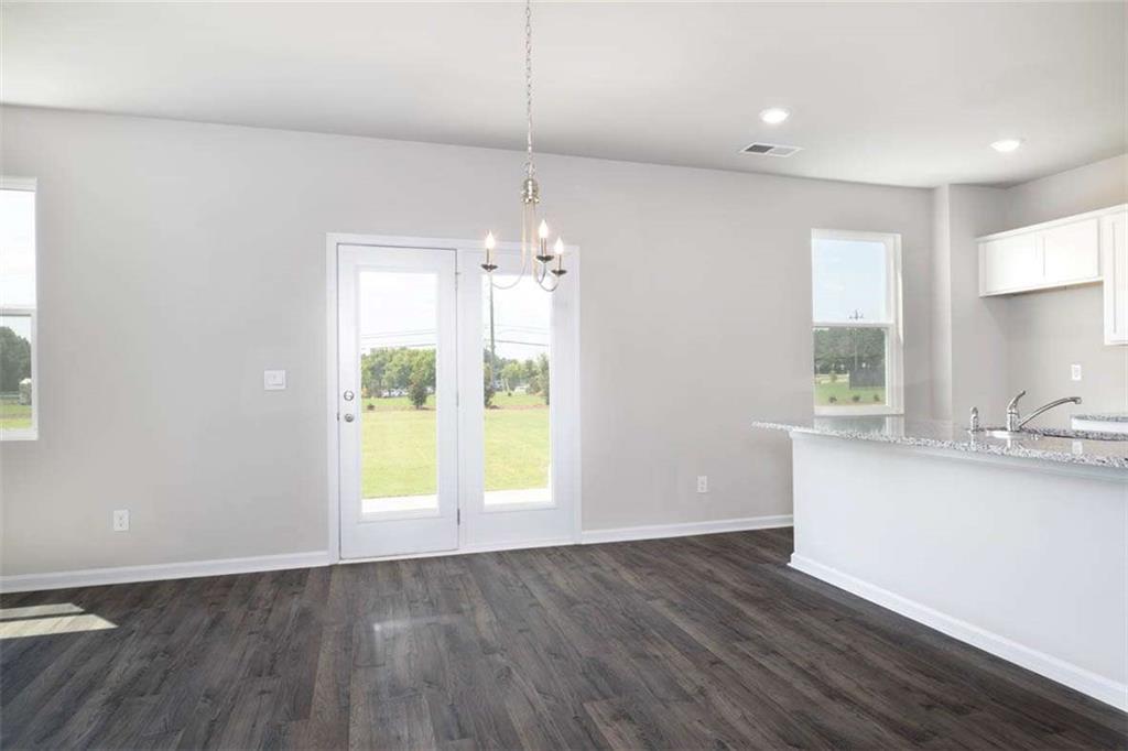 146 Aster Avenue Locust Grove, GA 30248 - Photo 19 of 28 an empty room with wooden floor and windows