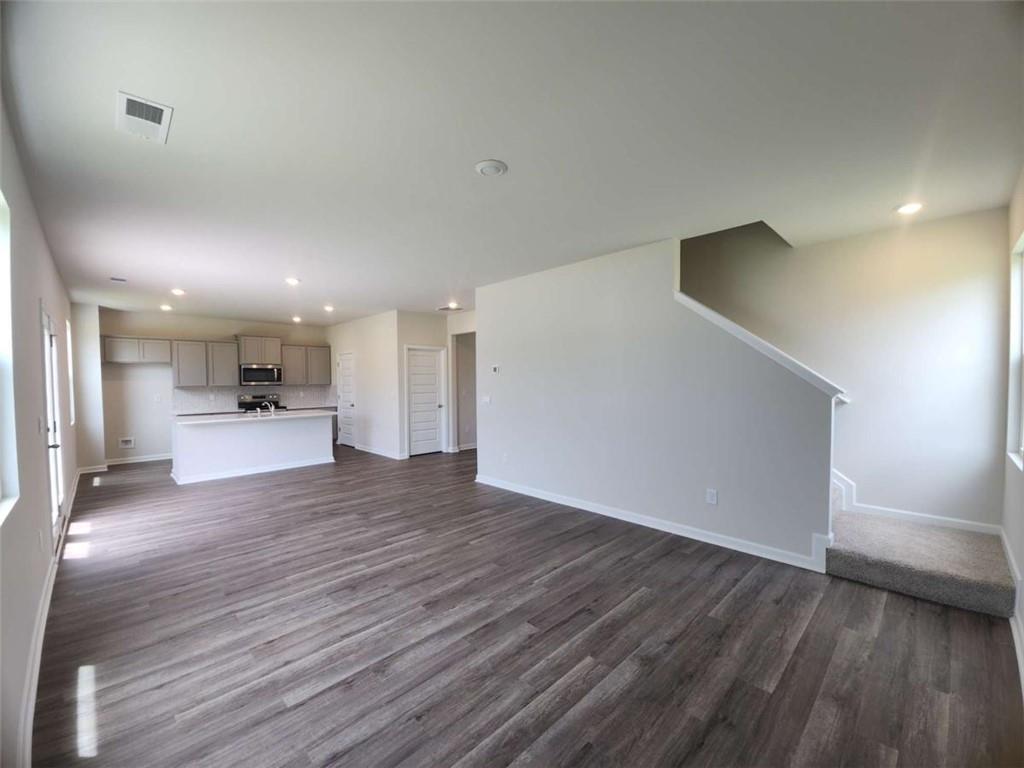 146 Aster Avenue Locust Grove, GA 30248 - Photo 9 of 28 a view of a big room with wooden floor and windows