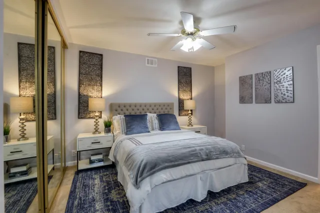 a bedroom with a large bed and a chandelier