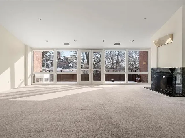 a view of an empty room with a fireplace and a large window