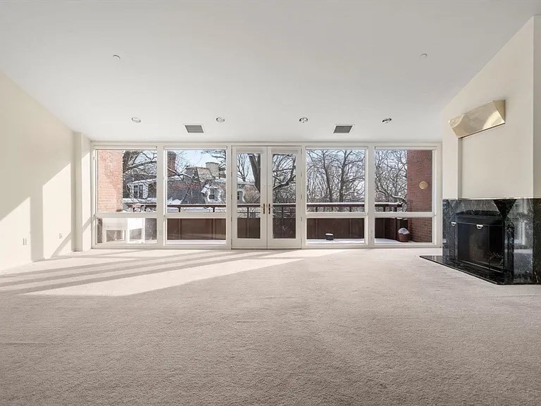 241 Perkins Street, Unit D605 Boston, MA 02130 - Photo 4 of 10 a view of an empty room with a fireplace and a large window